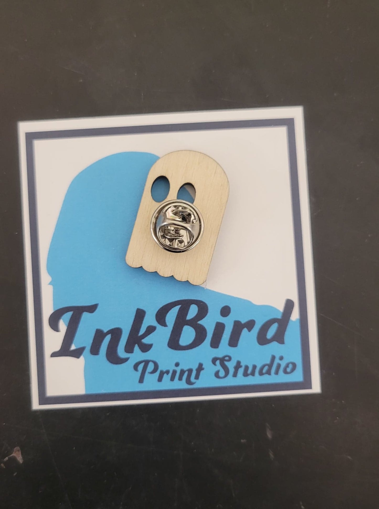 BOOner Ghost Pin: laser-cut birch wood, two black eyes, metal clasp; mounted on card with InkBird Print Studio and blue bird logo.