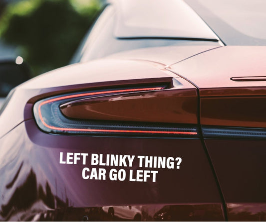 Close-up of red car’s rear with InkBird Print Studio LLC vinyl turn signal decal, white text: “LEFT BLINKY THING? CAR GO LEFT.”.