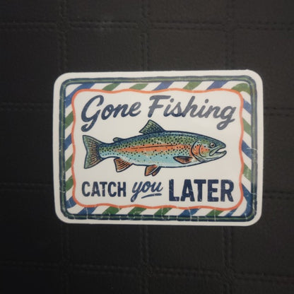 Colorful vinyl die cut sticker by InkBird Print Studio LLC, featuring a fish, “Gone Fishing” text, white background, striped border. Printed for Good Days Marina