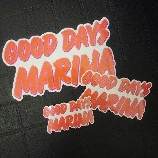 Set of 3 die cut vinyl stickers in varying sizes with bold red and pink GOOD DAYS MARINA text in a playful font on black.