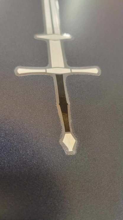 Vinyl Zweihander sword sticker by InkBird Print Studio, metallic silver/black foil, white blade, detailed crossguard, bold design.