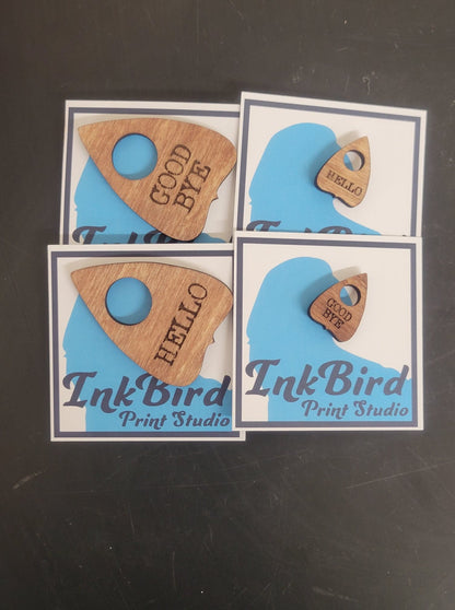 Set of four laser-cut wooden planchette pins by InkBird Print Studio, in large and small sizes, engraved with HELLO or GOOD BYE.