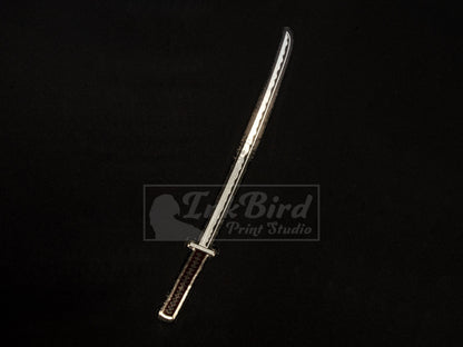 Vinyl sticker by InkBird Print Studio: metallic foil katana in silver and burgundy, sleek Japanese sword style. Adhesive backing.